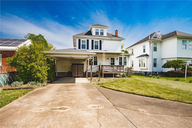 traditional style home featuring a chimney, a front lawn, driveway, covered porch, and an attached carport