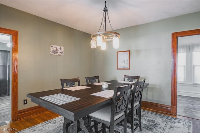 dining area with baseboards and wood finished floors