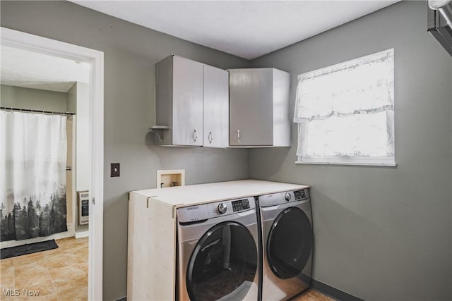 laundry area featuring washer and dryer, baseboards, cabinet space, and heating unit