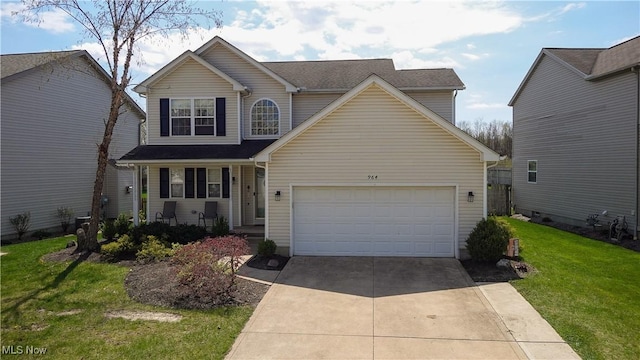 traditional-style home featuring an attached garage, a front lawn, and concrete driveway
