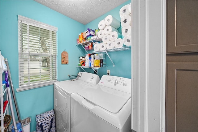 washroom with washing machine and dryer, a textured ceiling, and laundry area