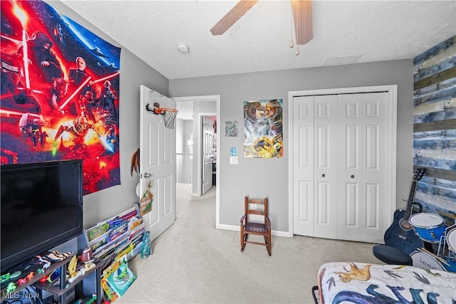 rec room with wood walls, a ceiling fan, a textured ceiling, and carpet