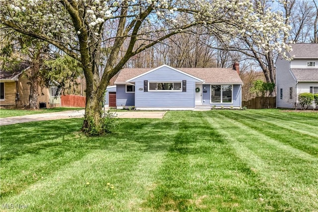 single story home with a front lawn, a chimney, and fence