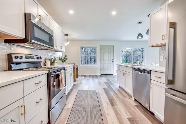 kitchen featuring light countertops, white cabinetry, stainless steel appliances, and a sink