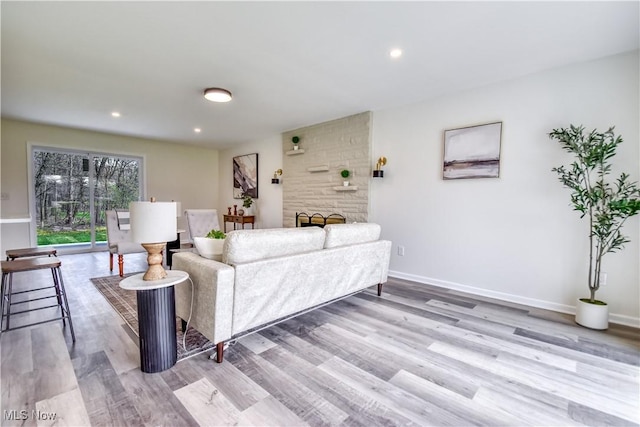 living area with recessed lighting, light wood-type flooring, and baseboards