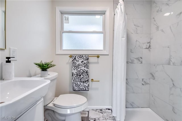 bathroom featuring toilet, a tile shower, baseboards, marble finish floor, and vanity
