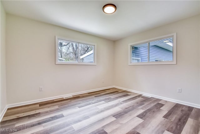 empty room featuring baseboards and wood finished floors