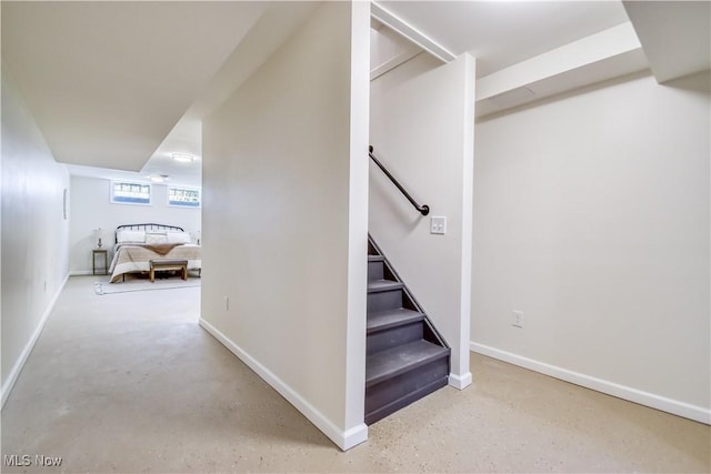 staircase with finished concrete flooring and baseboards