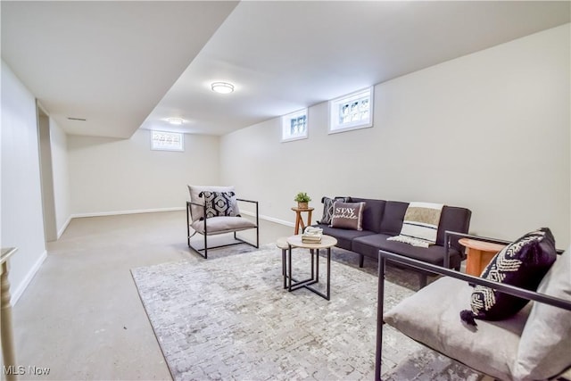 living area with baseboards and concrete flooring