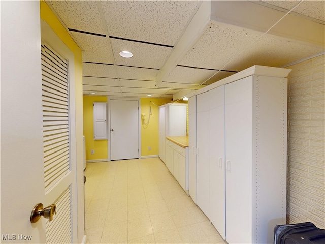 corridor featuring light floors, recessed lighting, and baseboards