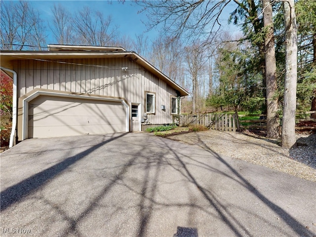 view of side of property with driveway and a garage