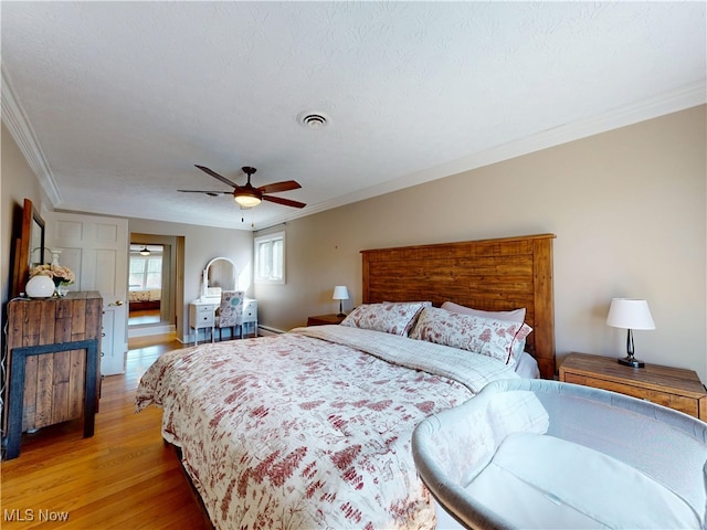 bedroom featuring ornamental molding, light wood-type flooring, and ceiling fan