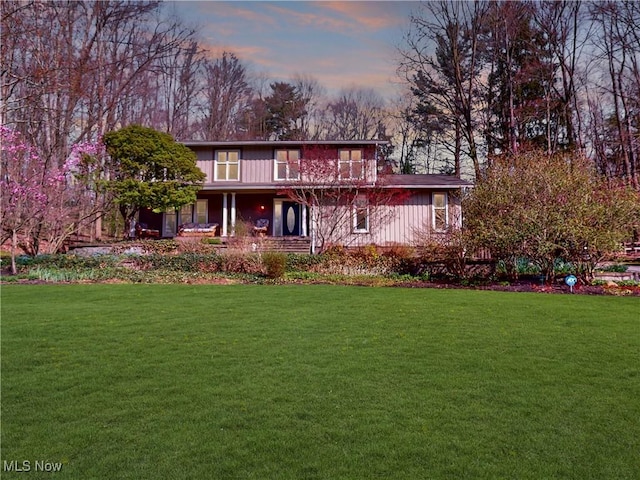 back of house with a yard and covered porch