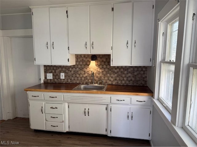 kitchen with white cabinets, tasteful backsplash, a wealth of natural light, and a sink