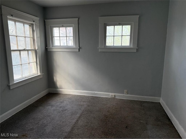 spare room featuring baseboards and carpet