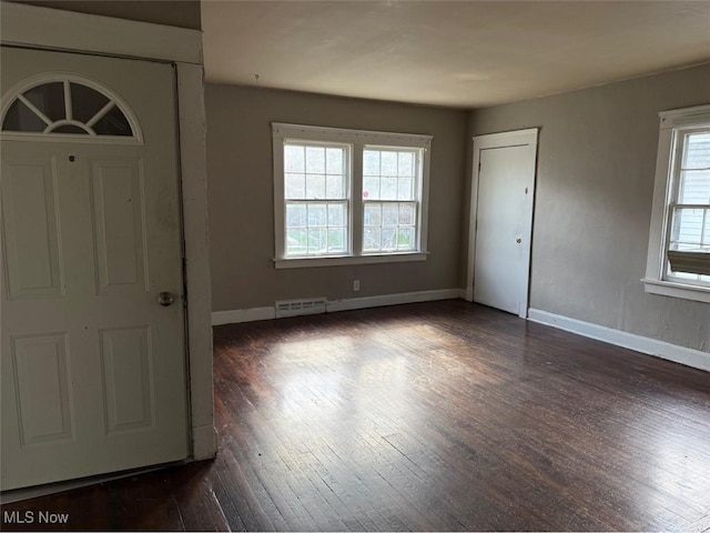 entrance foyer featuring baseboards, visible vents, and dark wood-style floors