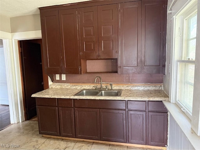 kitchen with light stone counters and a sink