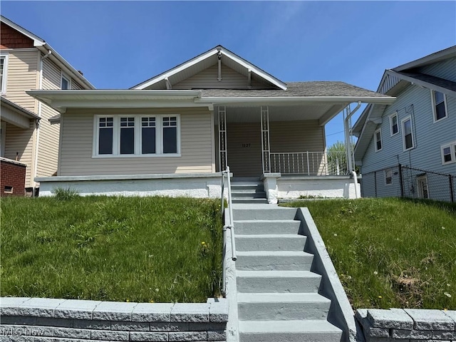 view of front of home with stairway, a porch, and roof with shingles