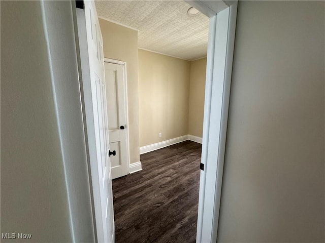 corridor featuring dark wood-style floors and baseboards