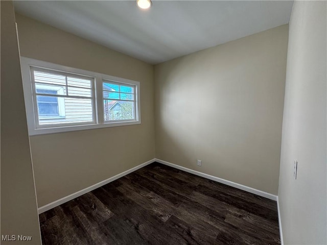empty room with baseboards and dark wood finished floors