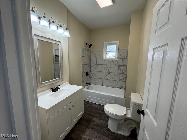 bathroom with toilet, vanity, wood finished floors, and shower / tub combination