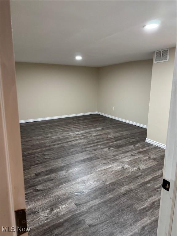 empty room featuring recessed lighting, visible vents, baseboards, and dark wood-type flooring