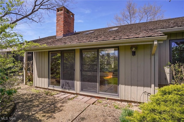 back of house with a chimney and a patio