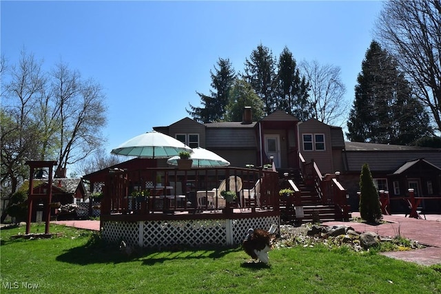 back of property with a wooden deck and a yard