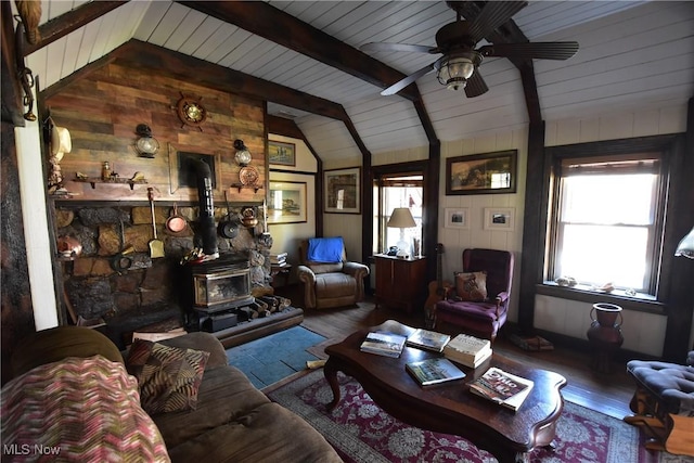 living room with a wood stove, wood finished floors, and a healthy amount of sunlight