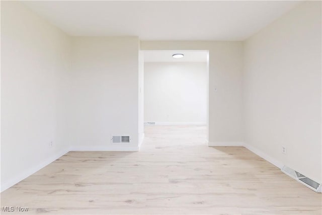 spare room with visible vents, wood finished floors, and baseboards