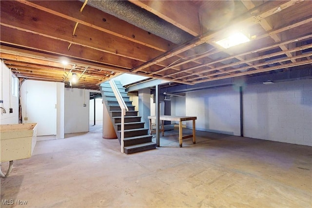 unfinished below grade area with stairs and a sink