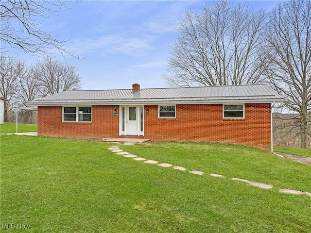 ranch-style house featuring metal roof, a front lawn, and brick siding
