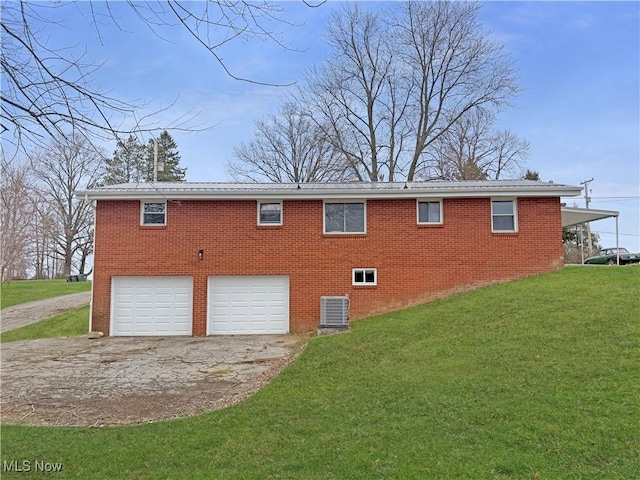 view of side of home featuring driveway, a lawn, central AC, and a garage