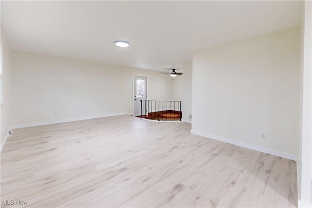spare room featuring light wood finished floors and baseboards