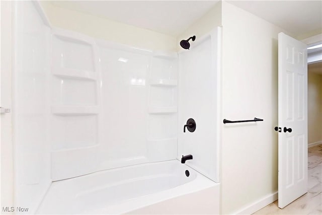 full bathroom with baseboards, tub / shower combination, and marble finish floor