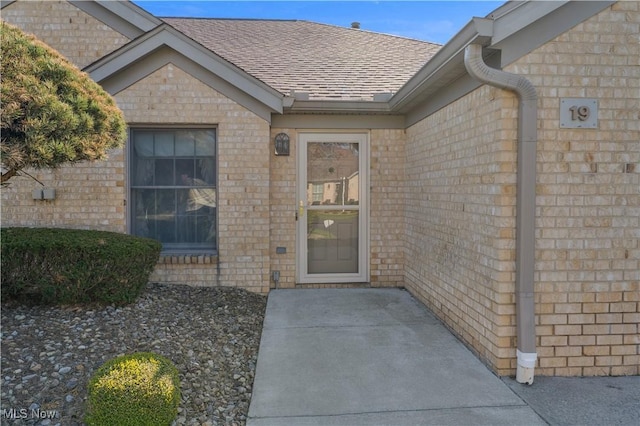 810 Southwestern Run Unit 19, Poland, OH 44514 - doorway to property with roof with shingles and brick siding