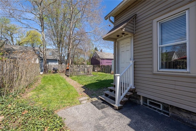 view of yard featuring entry steps and fence