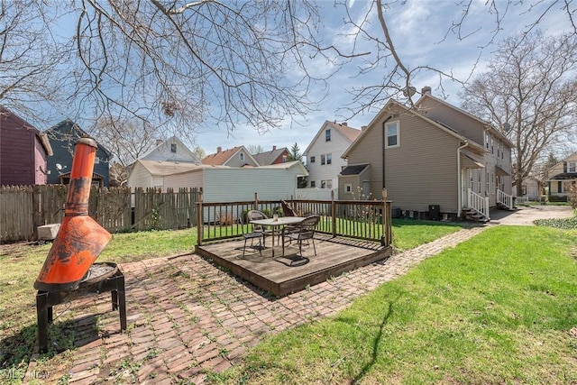 exterior space featuring a residential view, a deck, outdoor dining space, and fence