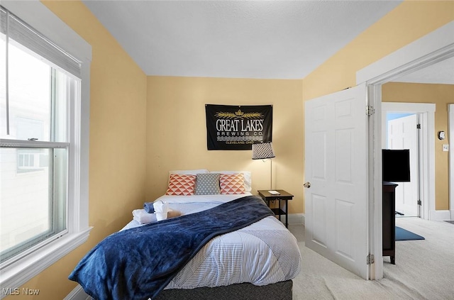 bedroom with multiple windows, carpet, and baseboards