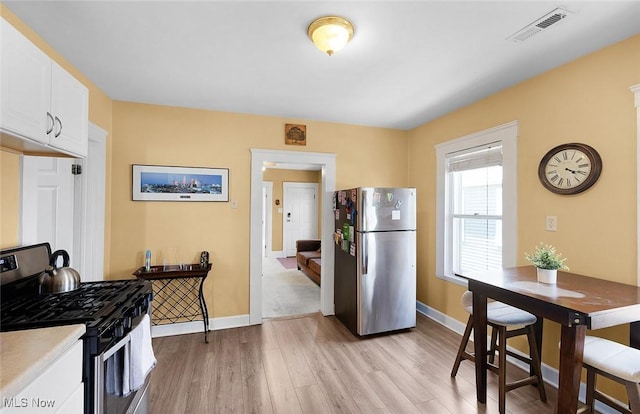 kitchen featuring white cabinetry, visible vents, appliances with stainless steel finishes, and light wood-style flooring