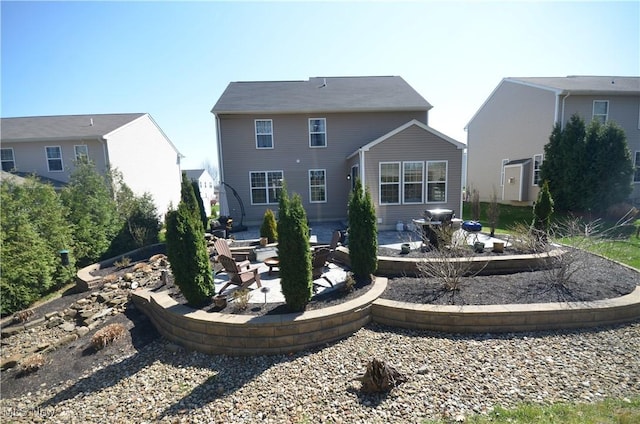 back of house with an outdoor fire pit and a patio