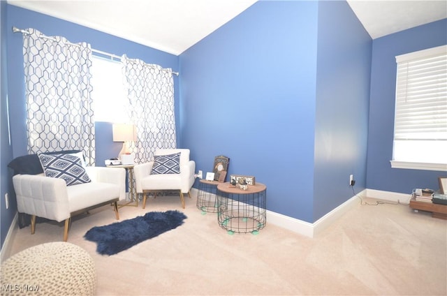 living area with baseboards, carpet floors, and lofted ceiling
