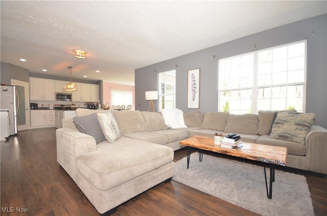 living room featuring dark wood-type flooring and recessed lighting