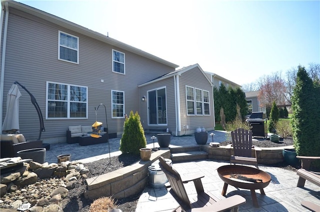 rear view of house with a fire pit and a patio area
