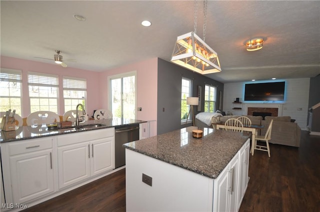 kitchen featuring a sink, dark wood-style flooring, a center island, dishwasher, and open floor plan
