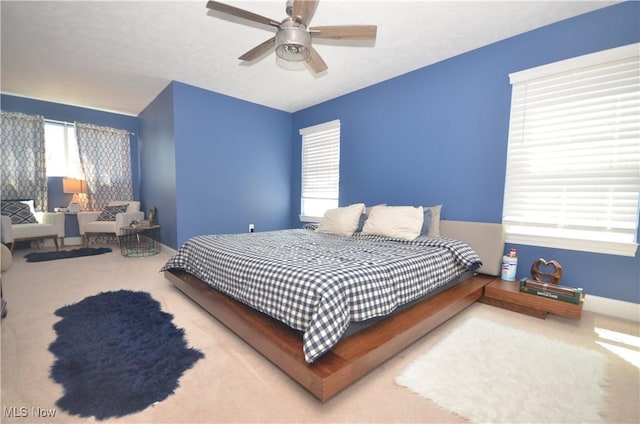 bedroom with a ceiling fan, carpet, and baseboards