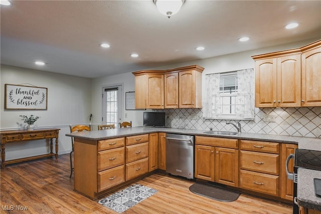kitchen featuring stainless steel dishwasher, decorative backsplash, electric range, a sink, and a peninsula