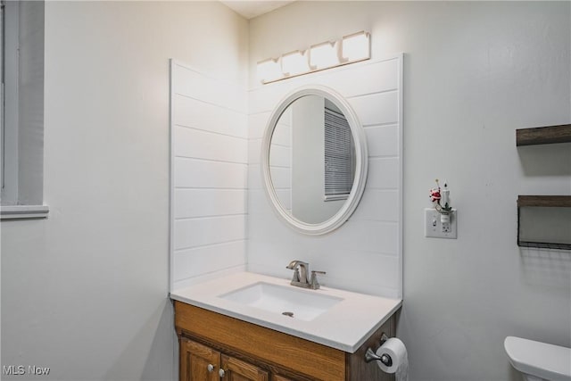 half bathroom with vanity and toilet