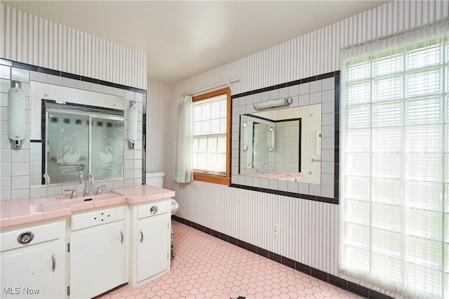 full bath featuring baseboards, wallpapered walls, a shower with shower door, and toilet