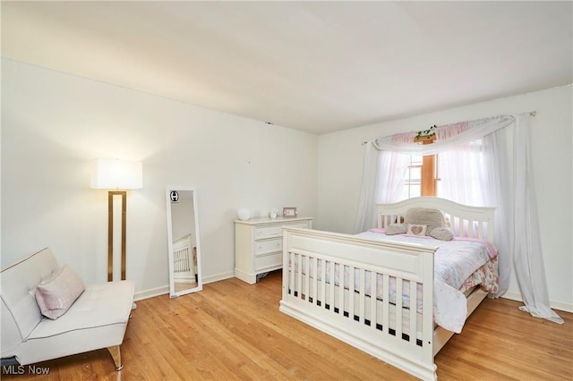 bedroom with baseboards and light wood-type flooring